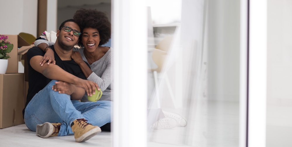 Reputable moving company in action, showing a happy couple in their new home surrounded by boxes